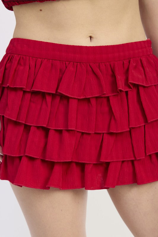 Red ruffled skirt worn by a person on a white background