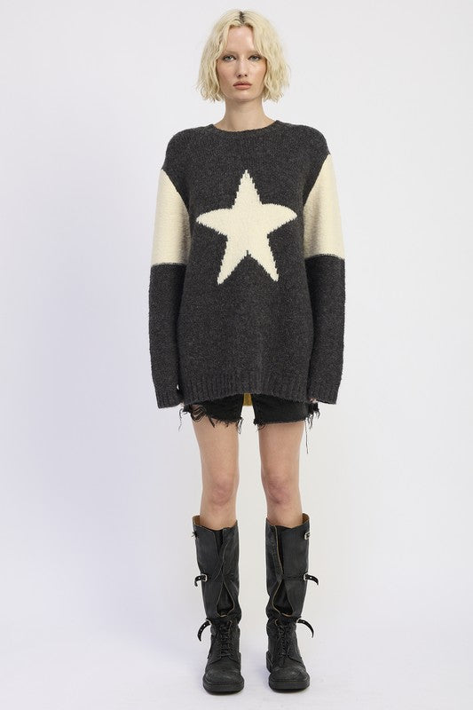 Person wearing a black and white star-patterned sweater on a white background