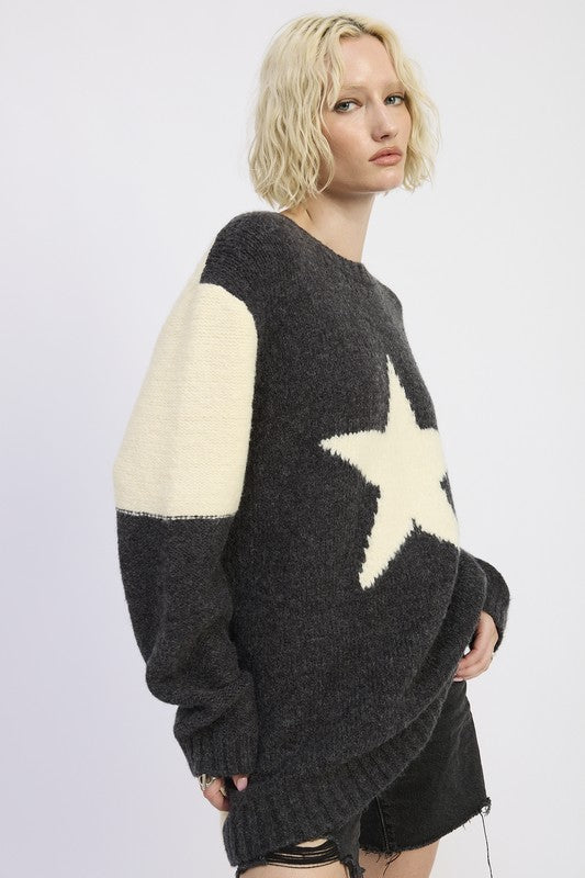 Person wearing a black and cream sweater with a star design on a white background