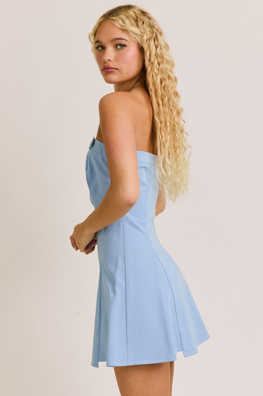 Woman in blue dress with long blonde curly hair.