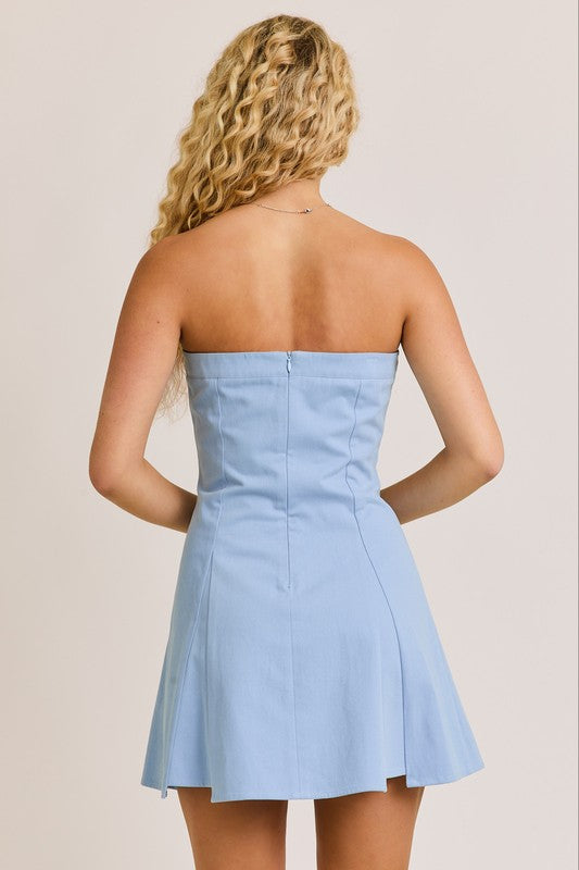 Woman in a light blue strapless dress, back view.
