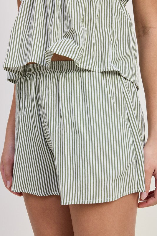 Green and white striped outfit with shorts and top on a light background