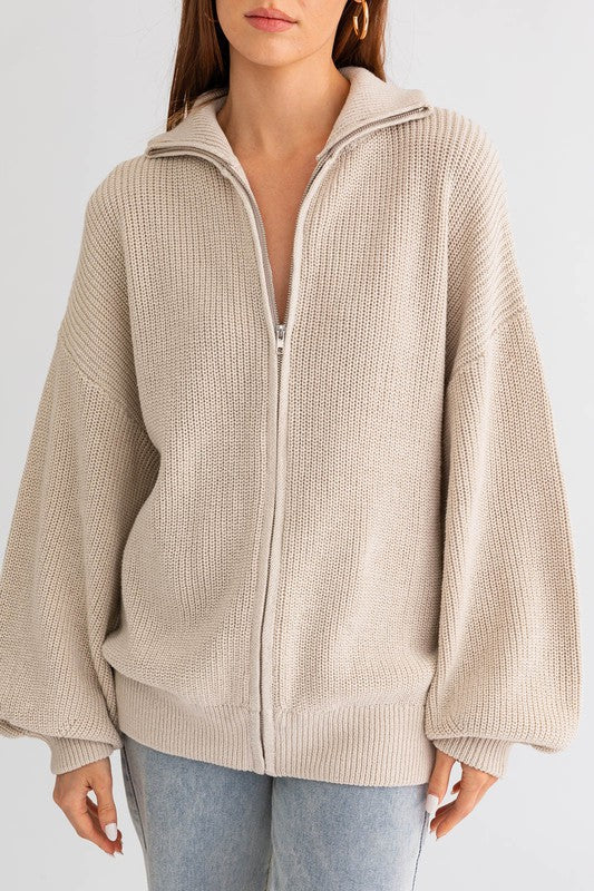 Beige zip-up hoodie worn by a person on a white background