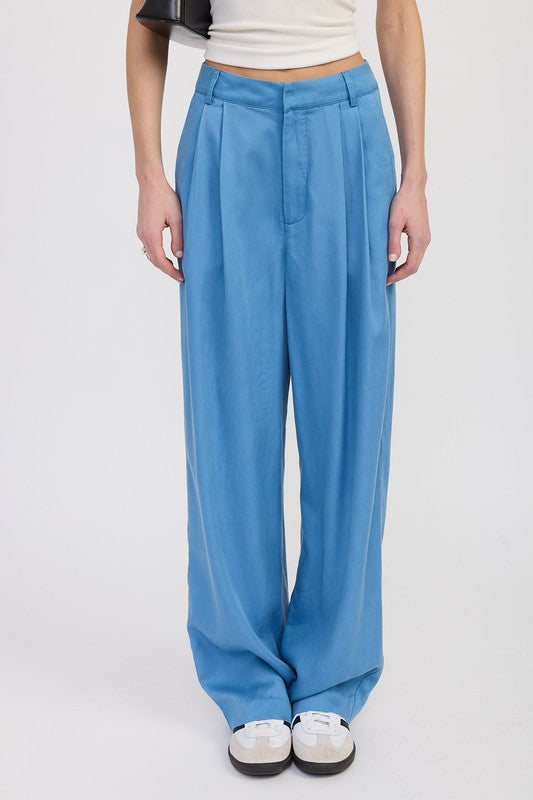 Person wearing blue wide-leg pants on a white background