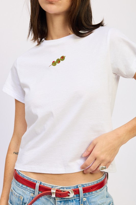 Person wearing a white t-shirt with a small design on a plain background