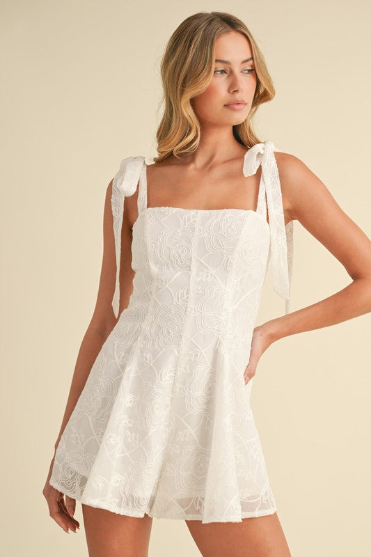 Woman in white summer dress with tie straps.