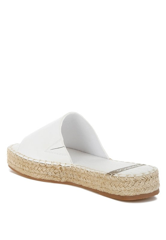 White slide sandal with a woven sole on a white background