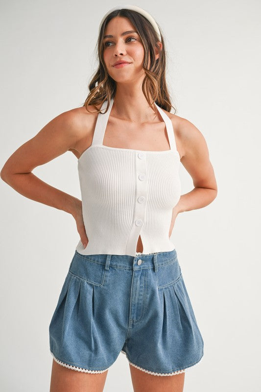 Woman in white top and denim shorts.