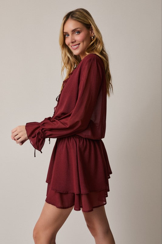 Woman wearing a burgundy dress against a plain background